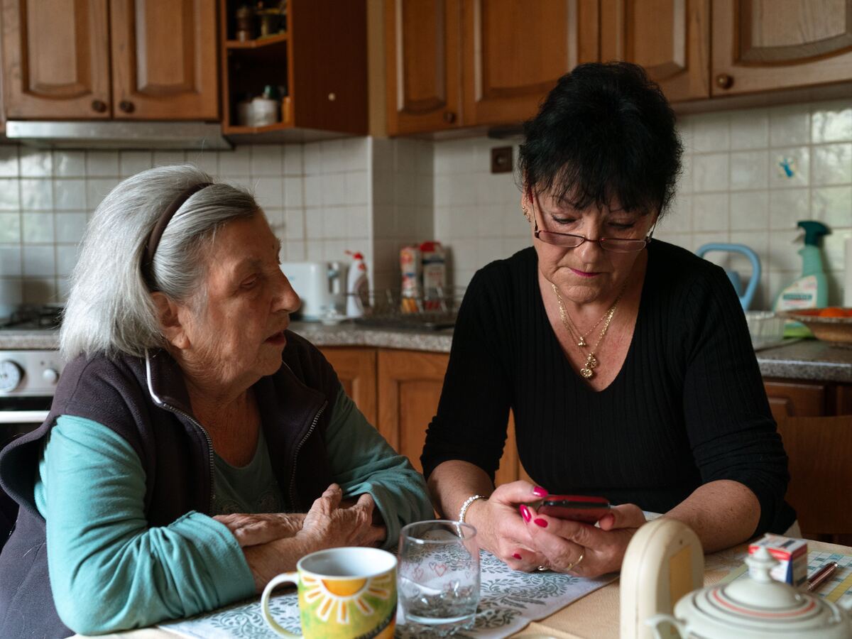 Carer sitting with a client at the kitchen table, talking things through together